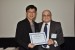 Dr. Nagib Callaos, General Chair, giving Mr. Tze Yong Tan the best paper award certificate of the session "Qualitative Research and Integrating Academic Activities II." The title of the awarded paper is "Infusing 21st Century Competencies into the Curriculum: A School-Level, Multi-Disciplinary Perspective."